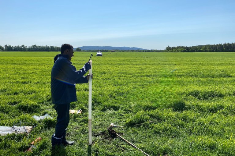 Miyuru Gunathilake installerer instrumenter for måling av grunnvannsnivå ved ett av forsøksfeltene i Farstad i Hustadvika kommune i Møre og Romsdal. Foto: Mounir Takriti